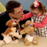 Dr. Stefan Friedrichsdorf talked quietly to Kali McKellips, 8, as she arranged her stuffed dogs for a picture. 